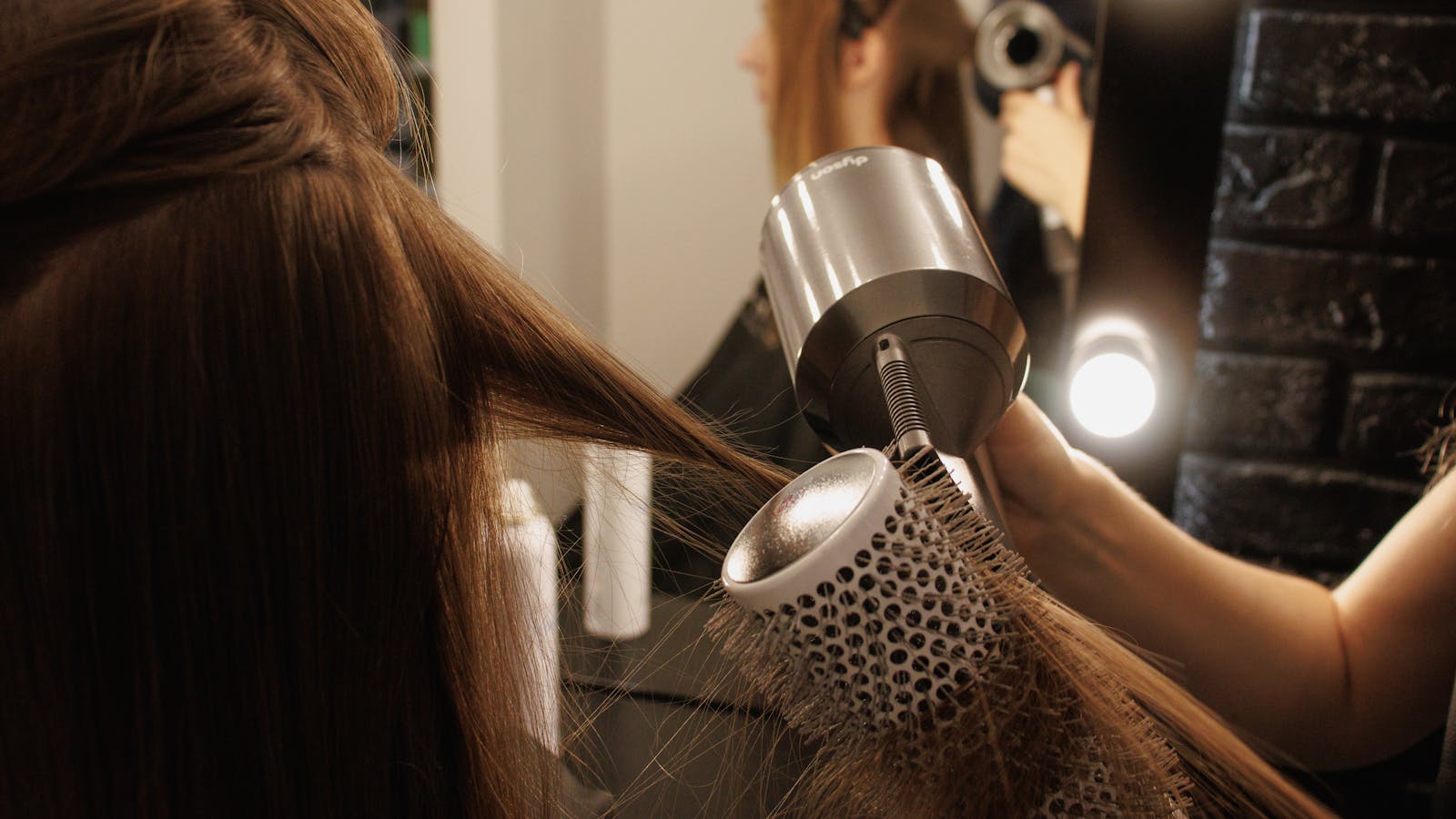 Round-brush blowout finish in the salon mirror
